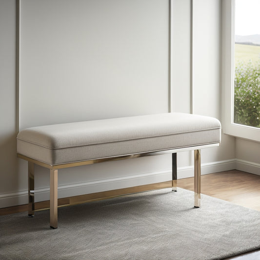 A sleek, low-profile bench in a neutral tone, adorned with metallic legs, sits against a crisp white wall, with a subtle lift-top storage compartment and a few tastefully arranged accessories.